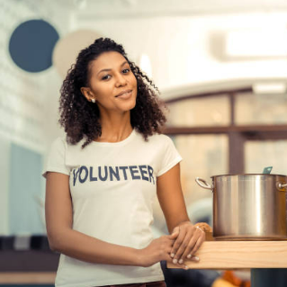 Woman at soup kitchen with a shirt that says, "volunteer."
